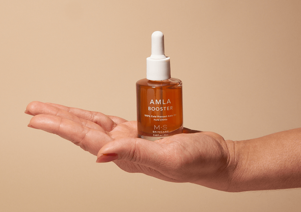 AMLA OIL bottle with natural background highlighting antioxidant-rich cold-pressed skincare and hair booster benefits
