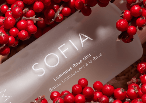 Bottle of Sofia botanical rose mist with red roses in background from Bulgaria's Rose Valley